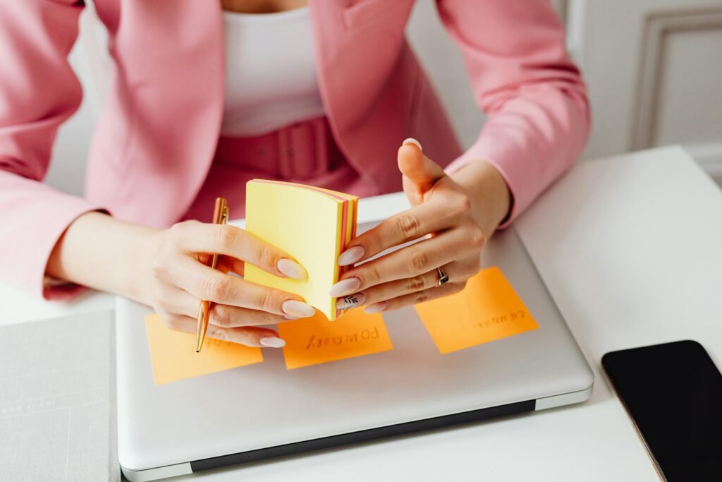 A Person in Pink Blazer Holding a Pad of Post-it Note